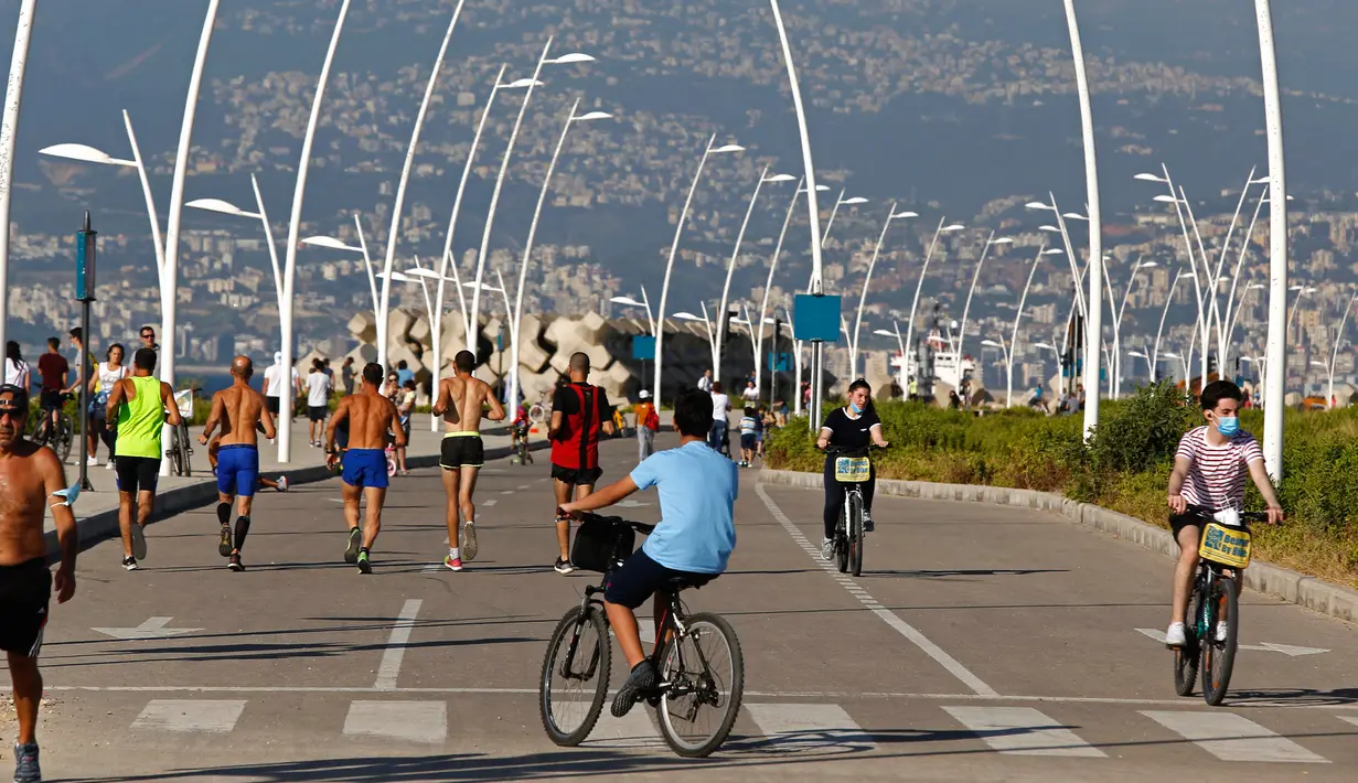 Orang-orang menikmati kegiatan bersepeda di pinggir pantai di Beirut, Lebanon (11/6/2020). Belakangan ini, kegiatan bersepeda menjadi aktivitas yang lazim di Lebanon sejak pemerintah memberlakukan pembatasan guna meredam pandemi COVID-19. (Xinhua/Bilal Jawich)