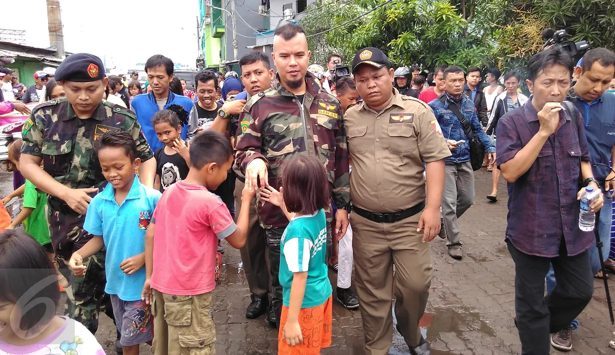 Sejumlah anak berebut mencium tangan dan bersalaman dengan musisi Ahmad Dhani saat tiba di  lokalisasi Kalijodo, Penjaringan, Jakarta, Senin (15/2). Suami dari Mulan Jameela itu mendatangi Kalijodo dikawal Banser Nahdlatul Ulama (NU). (Foto : Muslim AR)