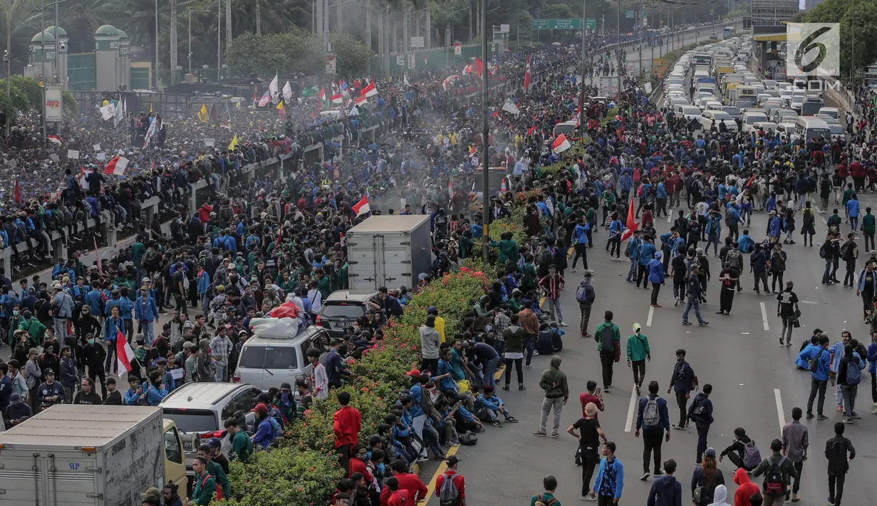 Massa mahasiswa memblokade Tol Dalam Kota saat berunjuk rasa di depan Gedung DPR/ MPR RI, Jakarta, Selasa (24/9/2019). Unjuk rasa menuntut penolakan atas pengesahan sejumlah RUU kontroversial tersebut diwarnai aksi bakar sejumlah kardus di tol dalam kota. (Liputan6.com/Faizal Fanani)