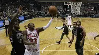 Penggawa Chicago Bulls Kris Dunn coba memasukkan bola pada laga NBA 2017-2018 melawan Milwaukee Bucks di BMO Harris Bradley Center, Jumat (15/12/2017) atau Sabtu (16/12/2017) WIB. (AP Photo/Morry Gash)