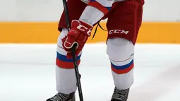 Aksi Presiden Rusia, Vladimir Putin memegang stick pada sesi latihan hoki es disaat perayaan natal umat kristen ortodoks di arena Galaktika, Sochi, Rabu (6/1/2016). (Aleksey NIKOLSKYI/Sputnik/AFP)
