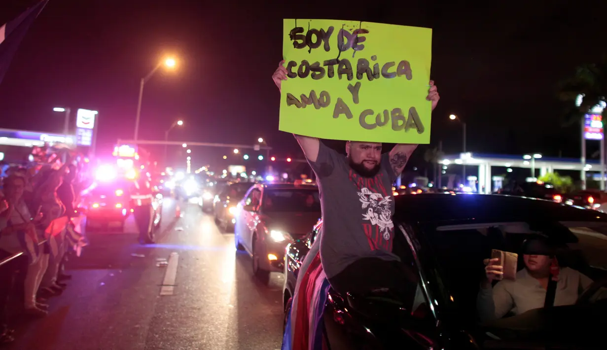 Warga Kuba bersorak saat turun ke jalan merayakan wafatnya Fidel Castro di Miami, AS (26/11). Mereka merupakan warga Kuba yang melarikan diri ke negara lain saat Castro berkuasa. (REUTERS/Javier Galeano)
