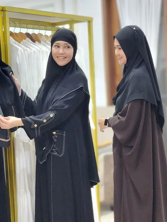 Kali ini, Maia memilih gamis berwarna hitam dengan detail kantong dan motif garis putih. Ia memadukan gamisnya dengan hijab bergo warna senada.  [@maiaestiantyreal]