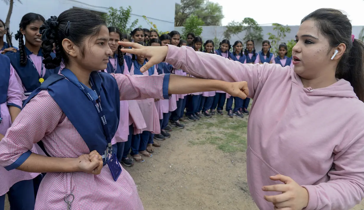 Juara karate internasional Muslim India, Syeda Falak mengajari teknik pukulan dalam bela diri kepada seorang siswi di Telangana Minorities Residential Girls School di Hyderabad, India (17/6). (AFP Photo/Noah Seelam)