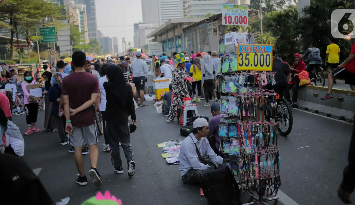 Pedagang kaki lima (PKL) berjualan di jalan saat car free day (CFD) di kawasan Bundaran HI, Jakarta, Minggu (6/10/2019). Banyaknya PKL nakal yang berjualan tidak pada tempatnya menyebabkan olahraga warga terganggu. (Liputan6.com/Faizal Fanani)
