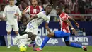 <p>Gelandang&nbsp;Atletico Madrid Geoffrey Kondogbia berebut bola dengan gelandang&nbsp;Real Madrid Eduardo Camavinga&nbsp; dengan skor tipis 1-0 atas Real Madrid. (AP Photo/Manu Fernandez)</p>