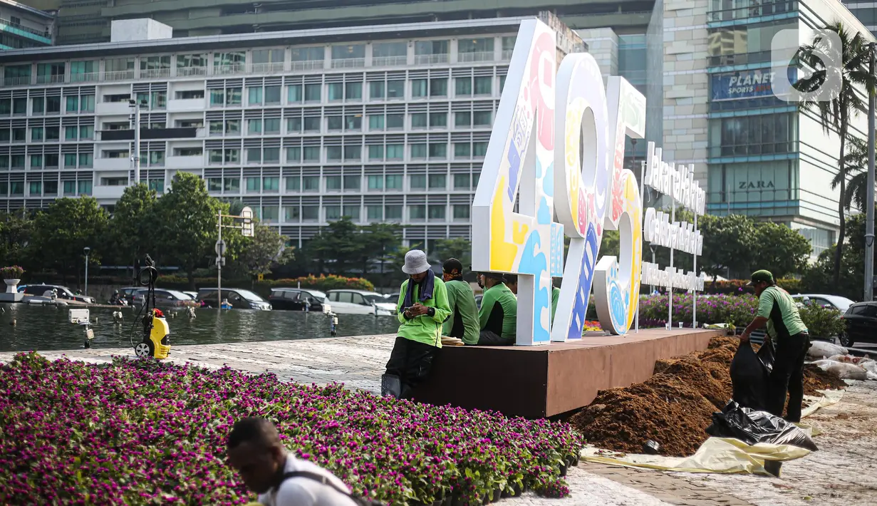 Pekerja dan petugas Dinas Pertamanan dan Kehutanan (Tamhut) DKI Jakarta melalukan persiapan dekorasi Jakarta Hajatan 495 di Bundaran HI, Jakarta Pusat, Senin (20/6/2022). Dekorasi berupa logo Jakarta Hajatan 495 dan peletakan bunga warna-warni di pinggir kolam Bundaran HI untuk memeriahkan HUT ke-495 Kota Jakarta. (Liputan6.com/Faizal Fanani)