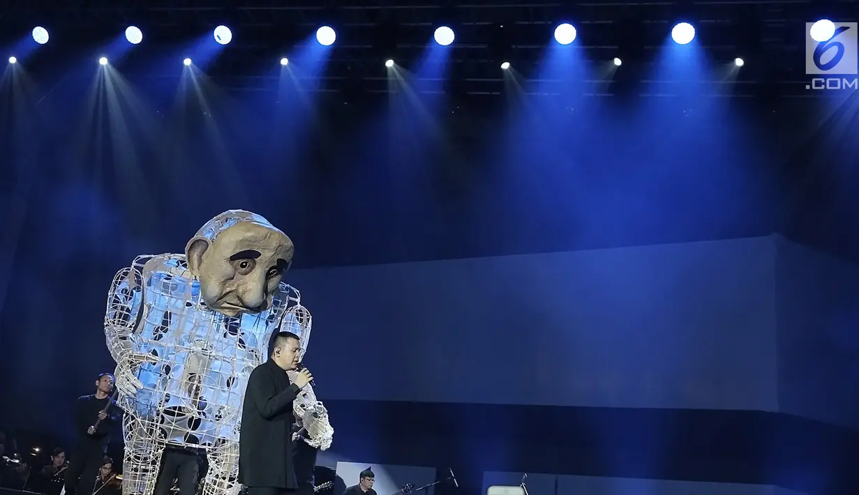 Penyanyi Muhammad Tulus Rusydi atau Tulus tampil bersama sebuah boneka dalam konser Monokrom di Istora Senayan, Jakarta, Rabu (6/2). Boneka ini merupakan bagian dari atraksi visual Pappermoon Puppet Theater dari Yogyakarta. (Fimela.com/Bambang Eros)