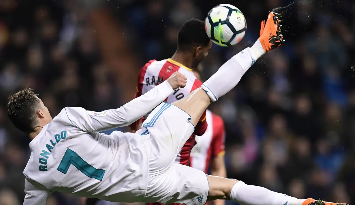 Striker Real Madrid, Cristiano Ronaldo, berebut bola dengan bek Girona, Jonas Ramalho, pada laga La Liga di Stadion Santiago Bernabeu, Senin (19/3/2018). Real Madrid menang 6-3 atas Girona. (AFP/Javier Soriano)
