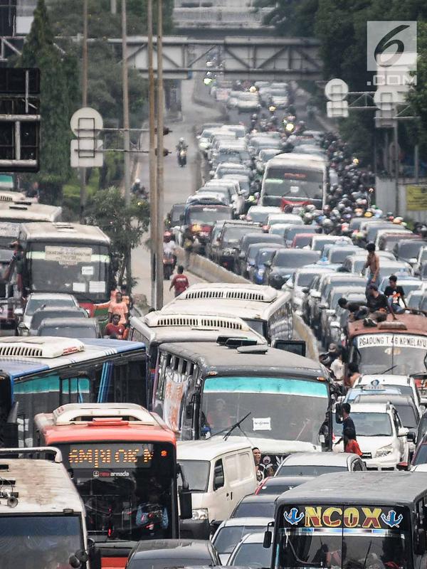 Kendaraan roda dua dan empat tampak terjebak macet panjang di kawasan Jalan Gatot Subroto, Jakarta, Minggu (9/12). Kemacetan tersebut diakibatkan oleh ribuan suporter yang ingin menunju ke Stadion Gelora Bung Karno. (Liputan6.com/Faizal Fanani)