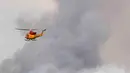 Sebuah helikopter pemadam kebakaran mengevakuasi kebakaran hutan di Fort McMurray, Alberta, Kanada 4 Mei 2016. Diperkirakan, api telah menghanguskan lebih dari 1.600 bangunan. (Courtesy MCpl VanPutten/CF Operasi/REUTERS)