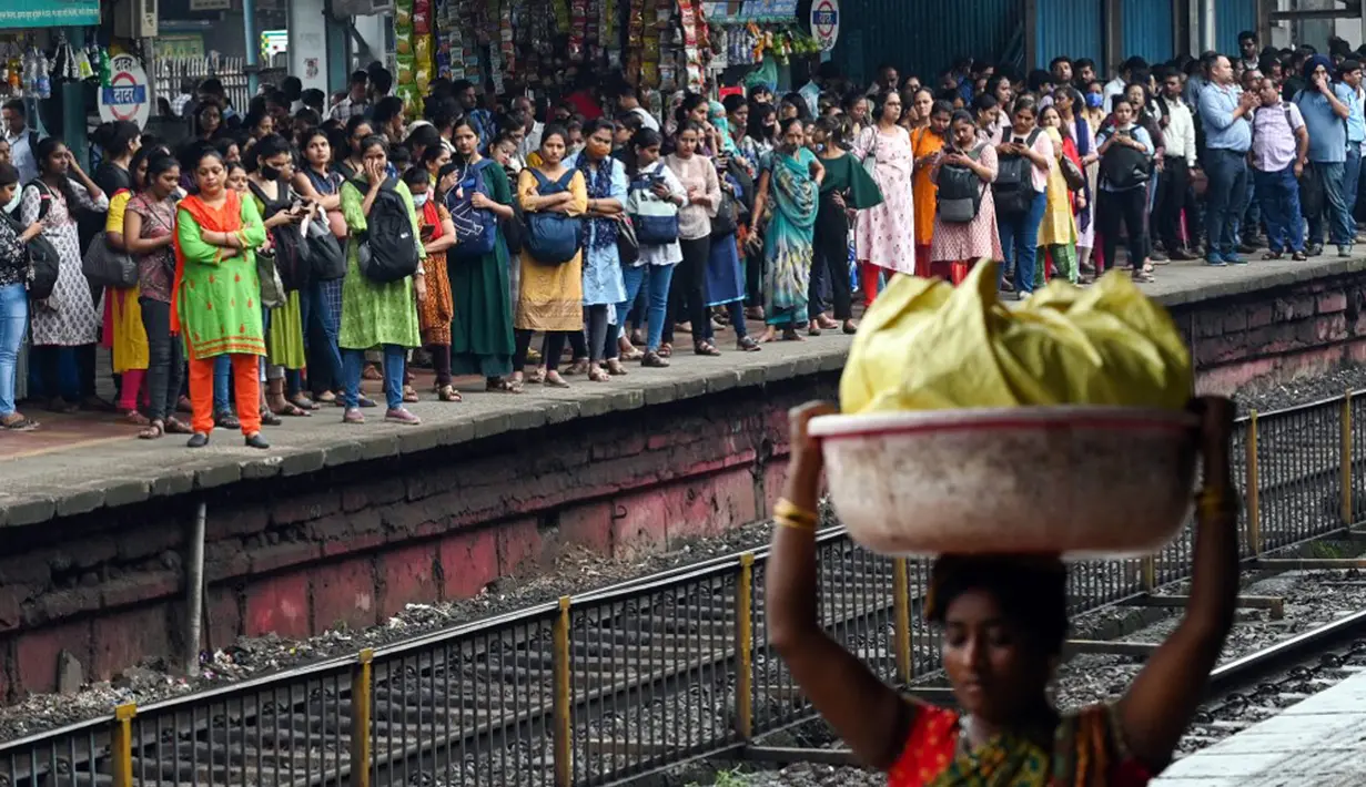 Penumpang menunggu kereta lokal tiba di Mumbai, India, Kamis (8/9/2022). Untuk kereta kelas ekonomi di India biasanya menggunakan lokomotif diesel. (Indranil MUKHERJEE/AFP)