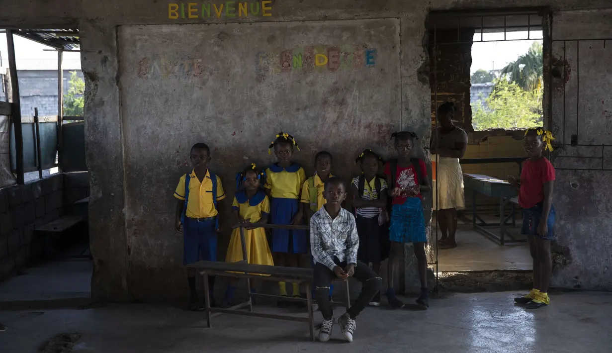 Para siswa berkumpul sebelum kelas dimulai di sekolah Sante Bernadette, di dalam Fort Dimanche, yang pernah menjadi penjara di mana mendiang diktator Haiti Francois "Papa Doc" Duvalier memenjarakan musuh-musuhnya, di Port-au-Prince, Haiti, Kamis (23/9/2021). (AP Photo/Rodrigo Abd)
