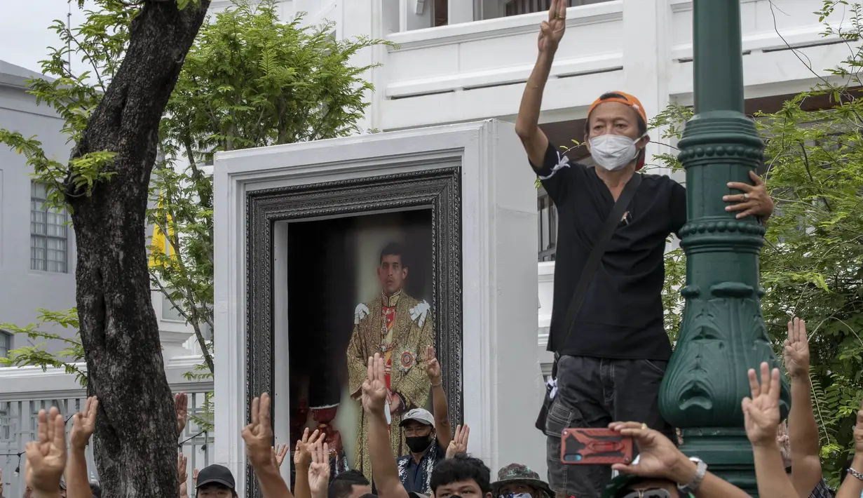 Pengunjuk rasa pro-demokrasi memberi hormat tiga jari, simbol perlawanan gerakan, saat mereka berbaris di dekat lapangan Sanam Luang di Bangkok, Thailand, Minggu (20/9/2020). (AP Photo)