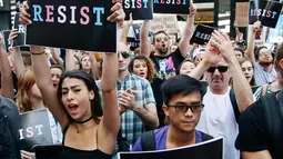 Sejumlah pendemo berorasi mengecam Donald Trump terkait larangan transgender masuk militer AS di Times Square, Rabu (26/7). Pemerintah belum memutuskan apakah transgender yang sudah bertugas di militer akan dikeluarkan atau tidak. (AP/Frank Franklin II)