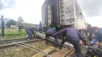Petugas evakuasi gabungan tengah mengangkat kereta yang tabrakan di jalur petak stasiun Cicalengka-Haurpugur Kabupaten Bandung, Jawa Barat. (Liputan6.com/Humas PT KAI Daop 2 Bandung)