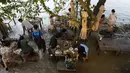 Pelanggan Chaopraya Antique Café di tepi sungai menikmati ketinggian air di Sungai Chao Phraya dekat Bangkok, Thailand, Kamis (7/10/2021). Restoran yang dilanda banjir ini menjadi tempat makan tidak biasa di mana pengunjung menikmati santapan makanan dengan kaki terendam. (AP Photo/Sakchai Lalit)