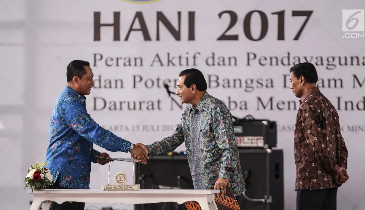 Kepala BNN, Komjen Pol Budi Waseso (kiri) bersalaman dengan Dirut Bank BRI Suprajarto disaksikan Menko Polhukam Wiranto usai menandatangani MoU antara bank BRI dan BNN dalam puncak peringatan HANI, Jakarta, Kamis (13/7). (Liputan6.com/Faizal Fanani)