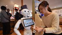 Seorang karyawati dari restoran sushi Hamazushi menguji coba robot humaoid Pepper saat press preview di Saitama, Jepang (2/2). Robot tersebut merupakan buatan dari perusahaan telekomunikasi raksasa Jepang yang bernama Softbank. (AFP/Kazuhiro Nogi)