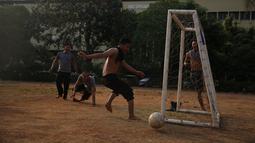 Polisi dari kesatuan Sabhara merenggangkan otot dengan bermain bola di Kawasan Polda Metro, Jakarta, Selasa (13/10/2015). Pihak Kepolisian dan TNI bersiap siaga menjelang laga Final Piala Presiden 2015. (Bola.com/Nicklas Hanoatubun).
