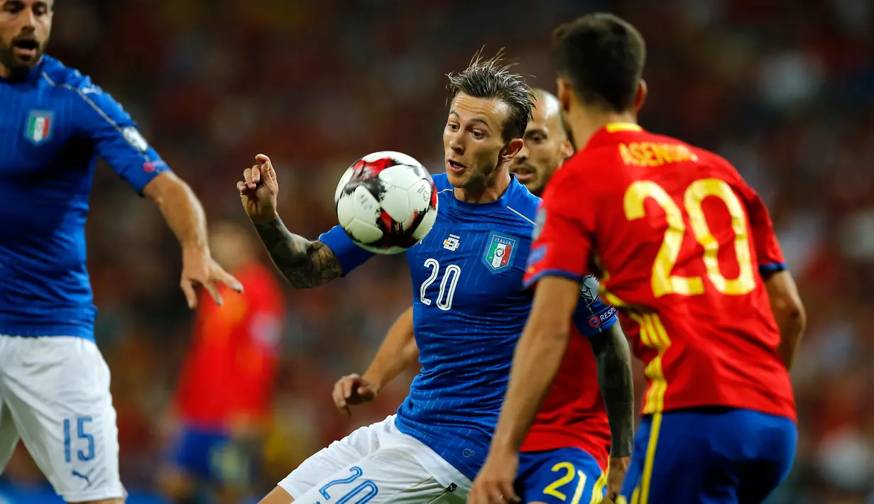 Gelandang Italia, Federico Bernardeschi (tengah) berusaha mengontrol bola dari kawalan pemain Spanyol saat bertanding di kualifikasi Piala Dunia 2018 di Stadion Santiago Bernabeu di Madrid, (2/9). Spanyol menang atas Italia 3-0. (AP Photo / Paul White)