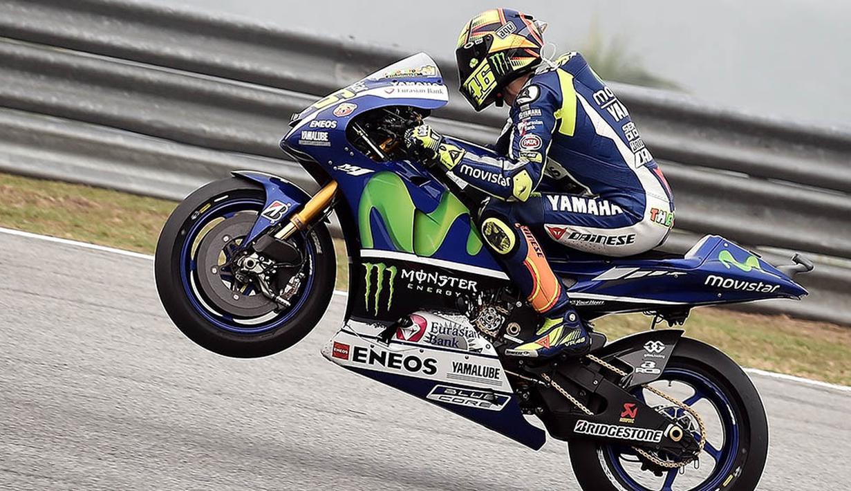 Pebalap Movistar Yamaha, Valentino Rossi, mengangkat ban depan pada sesi latihan MotoGP Malaysia di Sirkuit Sepang International, Malaysia. (AFP/Manan Vatsyayana)
