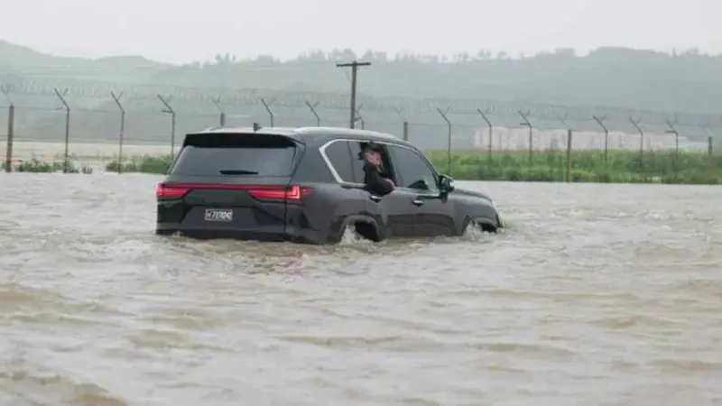 Kim Jong Un melintasi banjir di Korea Utara. (Rodong Sinmun)