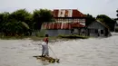 Seorang wanita naik perahu mengarungi area banjir di Munshiganj pinggiran Dhaka, Bangladesh, Senin (27/7/2020). Banjir telah menewaskan 119 orang di 21 (dari 64) distrik sejak 30 Juni lalu. (Xinhua)