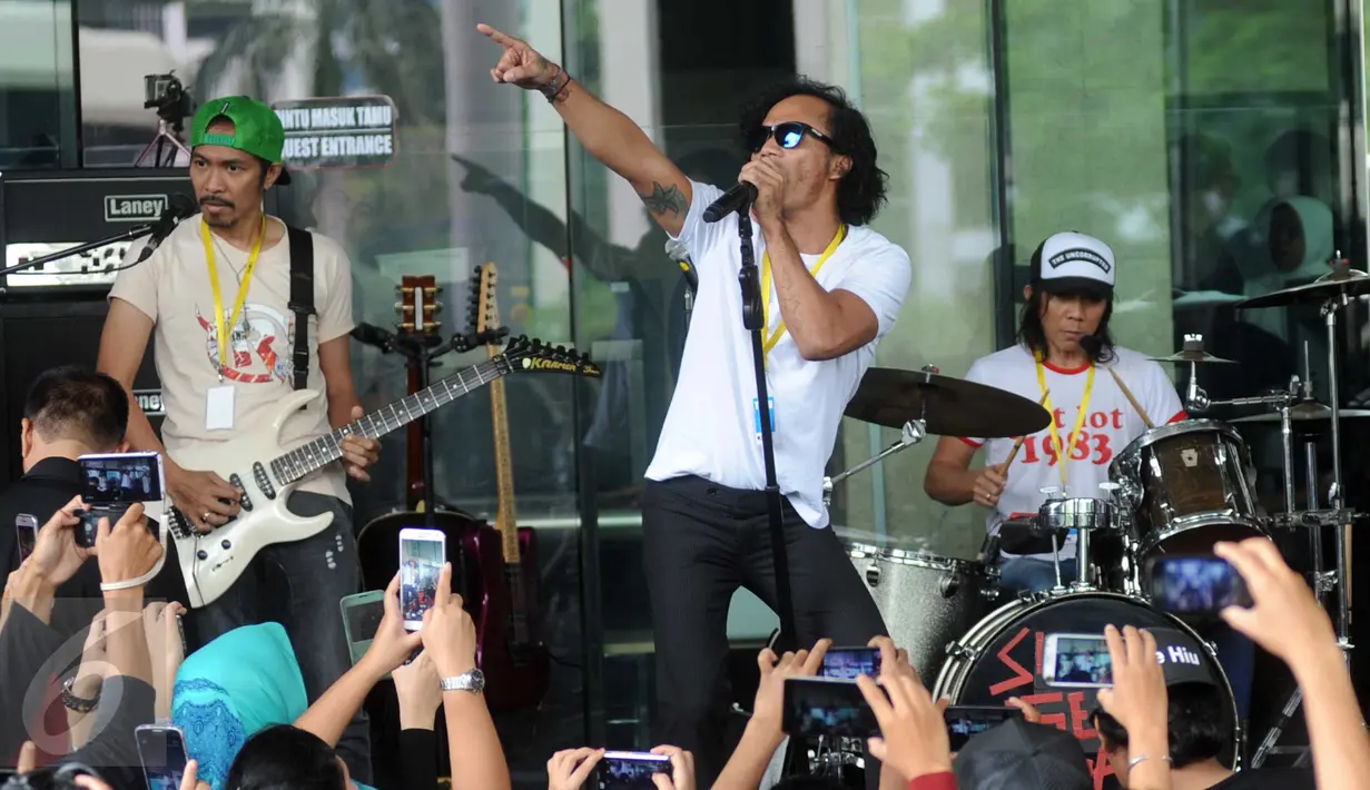 Grup band Slank beraksi saat konser di halaman Gedung KPK, Jakarta, Senin (22/2). Slank menggelar konser untuk memberikan dukungan kepada lembaga antirasuah itu dengan menolak rencana revisi UU Nomor 30 Tahun 2002 tentang KPK. (Liputan6.com/Helmi Afandi)