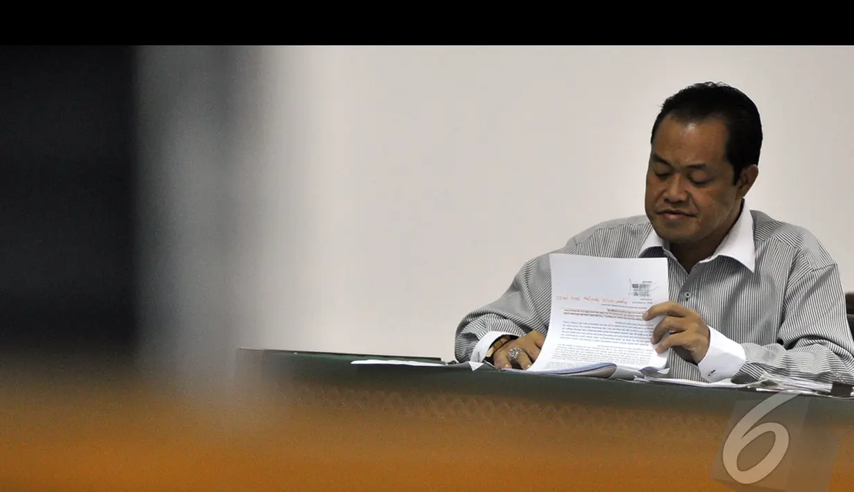 Muhtar Ependi melihat berkas saat menjalani sidang lanjutan di Pengadilan Tipikor, Jakarta, Kamis (15/1/2015). (Liputan6.com/Miftahul Hayat)