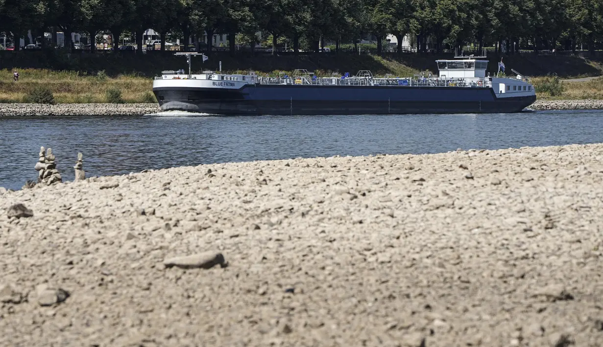 Sebuah kapal terlihat di Sungai Rhine dengan air yang rendah di Cologne, Jerman, Rabu (10/8/2022). Ketinggian air yang rendah mengancam industri Jerman karena semakin banyak kapal yang tidak dapat melintasi jalur air utama. Kekeringan yang parah akan memburuk di Eropa pada bulan Agustus karena musim panas yang panas dan kering terus berlanjut. (AP Photo/Martin Meissner)