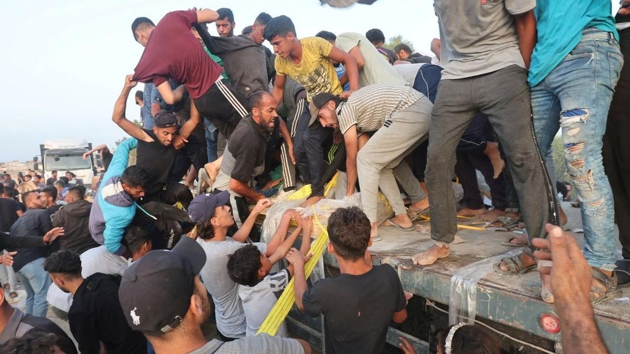 Dalam upaya untuk bertahan hidup, para pengungsi Palestina terpaksa membongkar paksa truk berisi bantuan kemanusiaan yang baru keluar dari Dermaga Trisula yang didirikan oleh Amerika Serikat. Foto: REUTERS / Ramadan Abed<br>