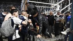 Laga di Stadion Juan Carmelo Zerillo menjadi daya tarik bagi para penonton. Hanya saja, laga harus dihentikan pada menit ke-9 karena situasi menjadi ricuh. Sejumlah penonton pun segera bergegas keluar dari tribune usai polisi menembakan gas air mata dari luar stadion. (AP Photo/Gustavo Garello)