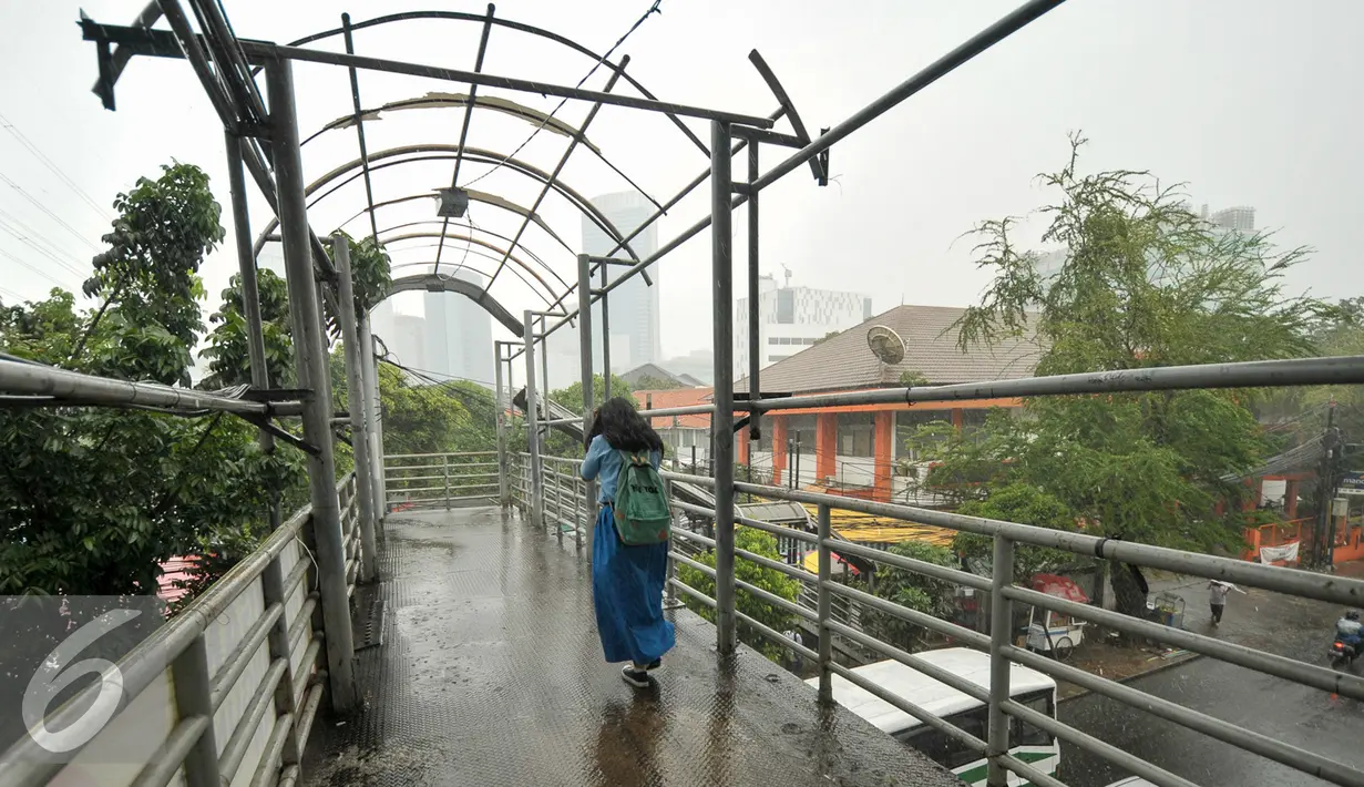 Seorang siswa melintasi jembatan penyeberangan orang (JPO) di Mampang, Jakarta, Selasa (17/1). JPO samping Kantor Pos Jalan Kapten Tendean, Mampang Prapatan kondisinya memprihatinkan dan butuh perbaikan. (Liputan6.com/Yoppy Renato)