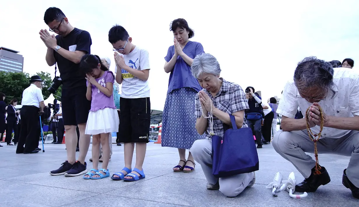 Warga Jepang berdoa untuk para korban bom atom menjelang peringatan di Hiroshima Peace Memorial Park, pusat kota Hiroshima, Selasa (5/8/2019). Pemerintah Jepang menggelar peringatan jatuhnya bom atom di Kota Hiroshoma 74 tahun lalu yang menandai berakhirnya Perang Dunia (PD) II. (JIJI PRESS / AFP)