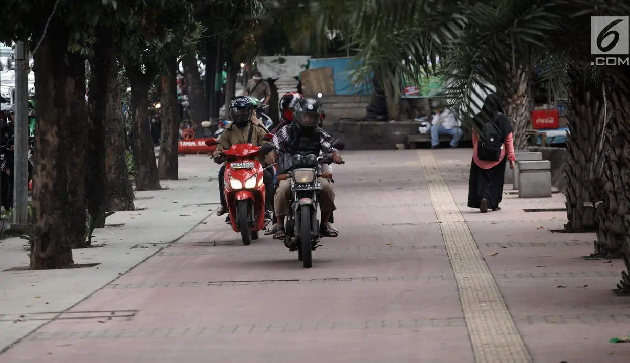 Sejumlah pengendara sepeda motor nekat menaiki jalur trotoar untuk menghindari kemacetan di Jalan Casablanca, Jakarta, Senin (8/1). Aksi tersebut memaksa pejalan kaki harus menepi menghindari kendaraan yang lewat. (Liputan6.com/Arya Manggala Nuswantoro)