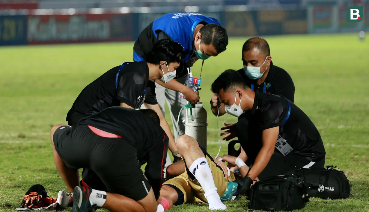 Sejumlah petugas tampak sigap memberikan bantuan kepada Kiper Bali United, Wawan Hendrawan, yang terkapar usai laga melawan Persib Bandung di laga BRI Liga 1 di Stadion Indomilk Arena. (Bola.com/M Iqbal Ichsan)