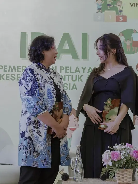 Ia mengenakan v-neck blouse berbahan suede dengan detail cape midi yang bikin terlihat anggun [@nikitawillyofficial94]