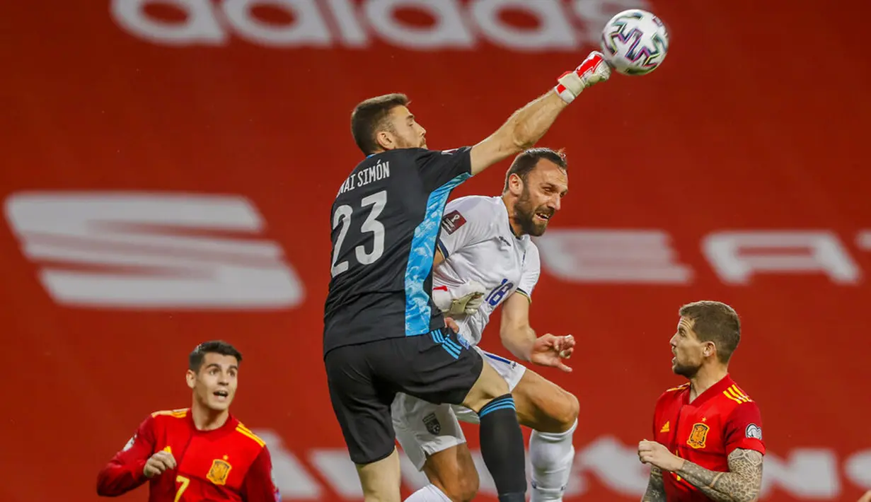 Kiper Spanyol Unai Simon menyelamatkan bola di samping pemain Kosovo Vedat Muriqi pada pertandingan Grup B babak kualifikasi Piala Dunia 2022 antara di Stadion La Cartuja, Seville, Spanyol, Rabu (31/3/2021). Spanyol menang 3-1. (AP Photo/Miguel Angel Morenatti)