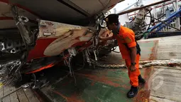 Petugas dari Basarnas memeriksa bangkai badan pesawat Airasia QZ8501 di Pelabuhan Tanjung Priok, Jakarta, Senin (2/3/2015). (Liputan6.com/Faizal Fanani)