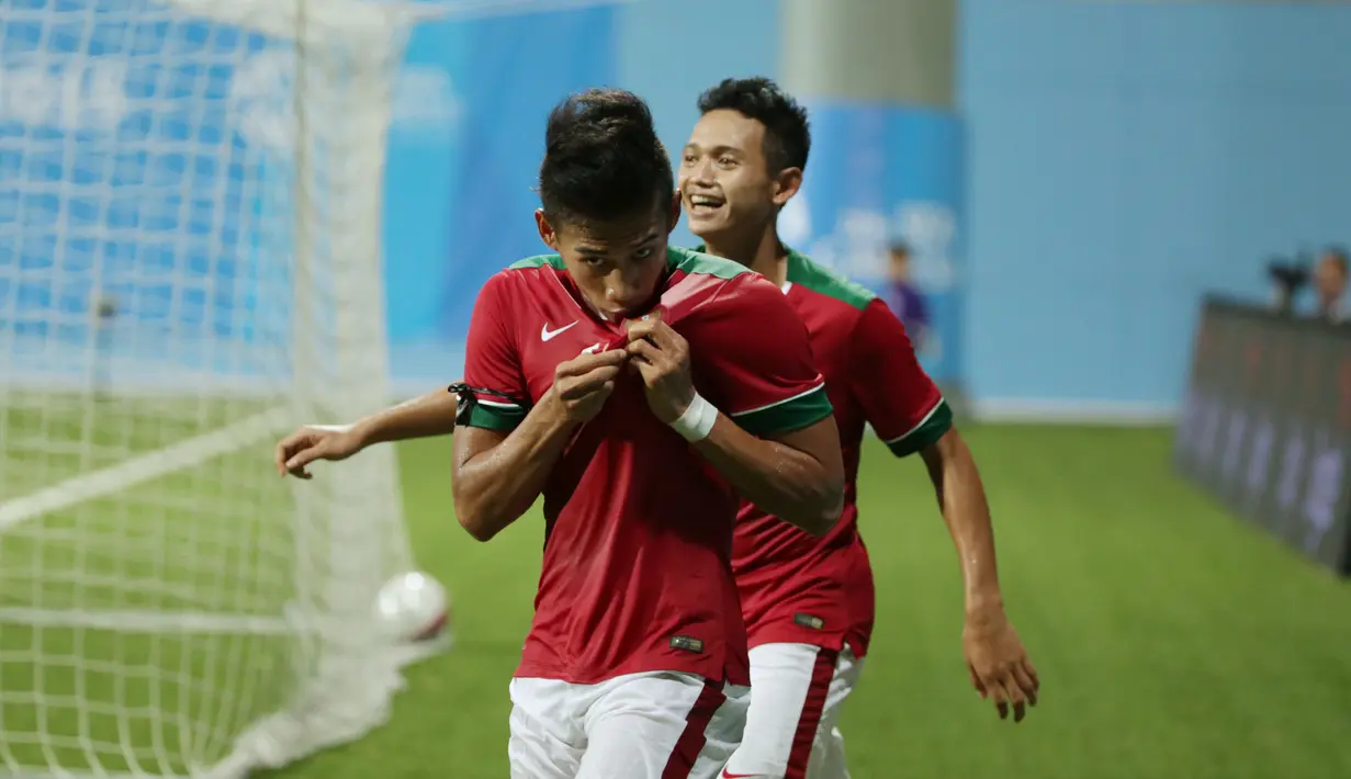 Gelandang timnas Indonesia U-23, Ahmad Nufiandani (depan) mencium lambang negara usai menjebol gawang Kamboja di penyisihan Grup A Sea Games 2015 di Stadion Jalan Besar, Singapura, Sabtu (6/6/2015). Indonesia unggul 6-1. (Liputan6.com/Helmi Fithriansyah)