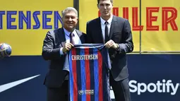 Bek baru Barcelona, Andreas Christensen (kanan) berfoto sambil memegang jersey barunya dengan Presiden Barcelona Spanyol Joan Laporta selama upacara presentasinya di tempat latihan Joan Gamper di Sant Joan Despi, dekat Barcelona (7/7/2022). Bek asal Denmark ini didatangkan secara gratis setelah kontraknya habis dengan Chelsea. (AFP/Pau Barrena)