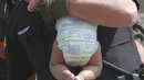 Seorang polisi Hazleton menggendong seorang bayi setelah kebakaran terjadi di sebuah gedung apartemen di Hazleton, Pennsylvania (26/7/2019). Pemadam kebakaran kota menggunakan truk menyelamatkan penghuni dari lantai tiga gedung. (Warren Ruda/Hazleton Standard-Speaker via AP)