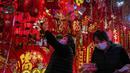 Seorang wanita memilih dekorasi Tahun Baru Imlek di sebuah mal di Beijing (16/1/2022). Beijing telah melaporkan infeksi omicron lokal pertamanya, beberapa minggu sebelum Olimpiade Musim Dingin akan dimulai. (AP Photo/Andy Wong)