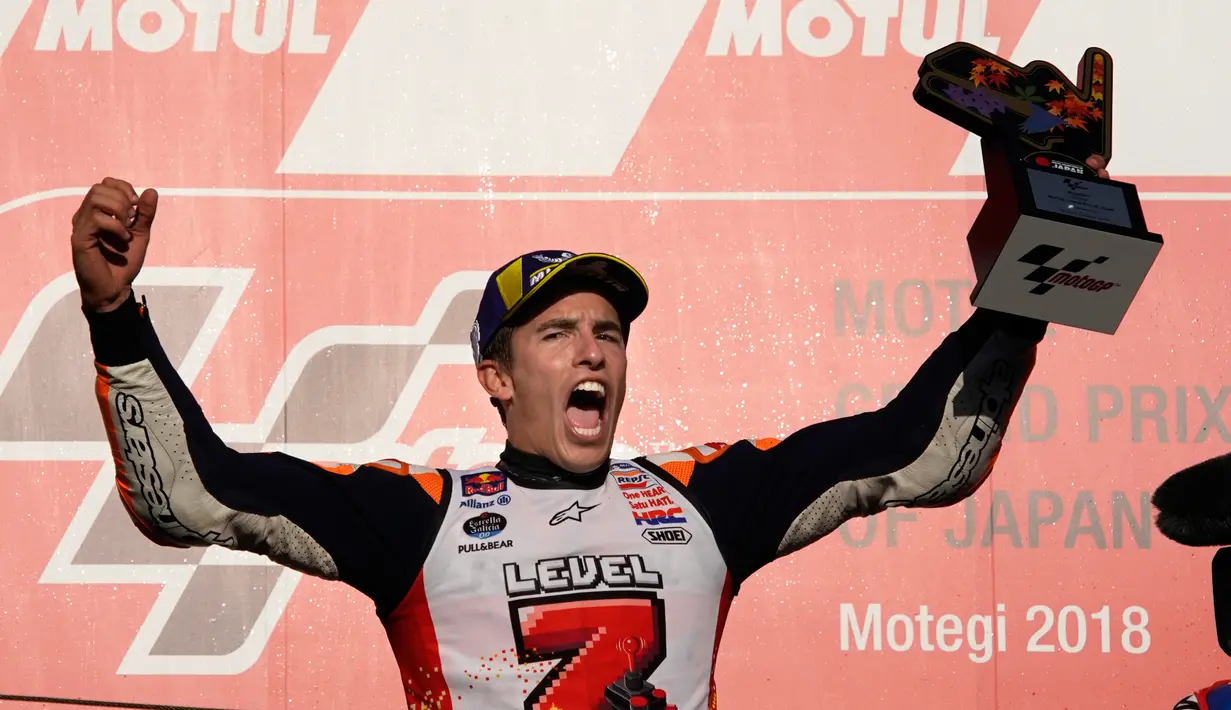 Pembalap Repsol Honda, Marc Marquez berselebrasi di atas podium setelah memenangi balapan MotoGP Jepang 2018 di Twin Ring Motegi, Minggu (21/10). Kemenangan Marquez di Jepang sekaligus membuatnya menjadi juara dunia MotoGP 2018. (AP/Shizuo Kambayashi)