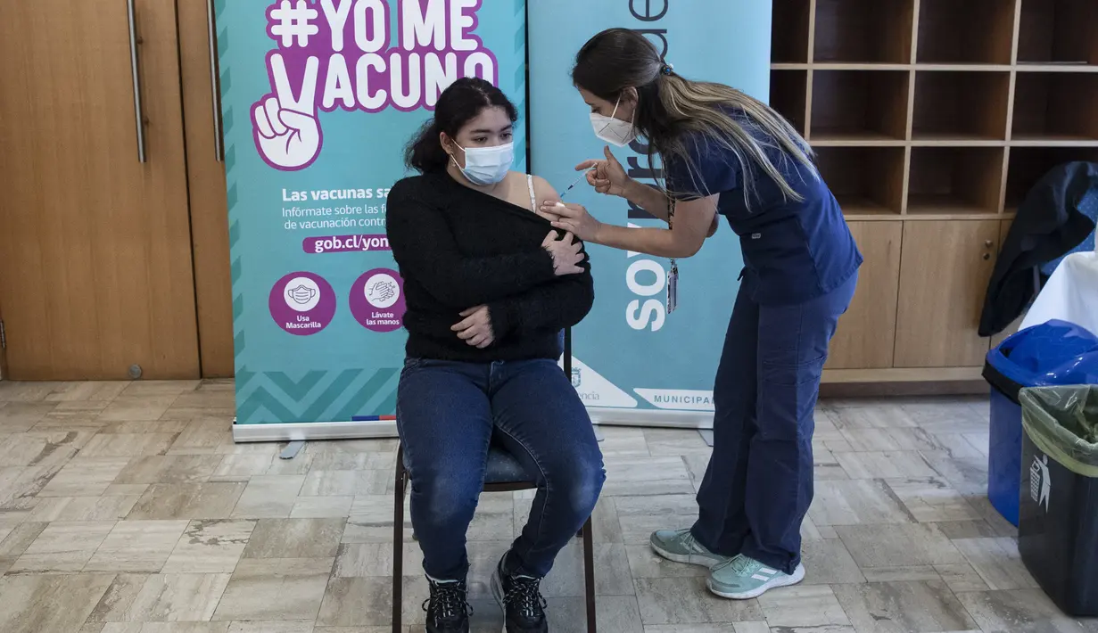 Petugas kesehatan menyuntikan vaksin COVID-19 Pfizer BioNTech kepada seorang anak di pusat vaksinasi di Santiago, Chile, Rabu (23/6/2021). Chile mulai memvaksinasi anak-anak dari usia 12 tahun, sebagai salah upaya untuk memutus rantai penyebaran infeksi virus Corona. (MARTIN BERNETTI/AFP)