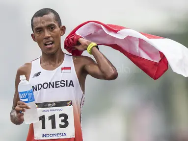 Pelari Indonesia, Agus Prayogo, melakukan selebrasi usai tampil pada nomor marathon SEA Games di Putrajaya, Kuala Lumpur, Sabtu (19/8/2017). Agus meraih medali perak dengan waktu dua jam 27 menit 16 detik. (Bola.com/Vitalis Yogi Trisna)