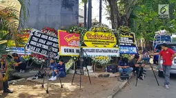 Sejumlah awak media berada di dekat karangan bunga di komplek Mako Brimob Kelapa Dua, Depok, Jawa Barat, Jumat (11/5). Karangan bunga ucapan bela sungkawa bertuliskan 'kami tidak takut, kami bersama Polri'. (Liputan6.com/Herman Zakharia)