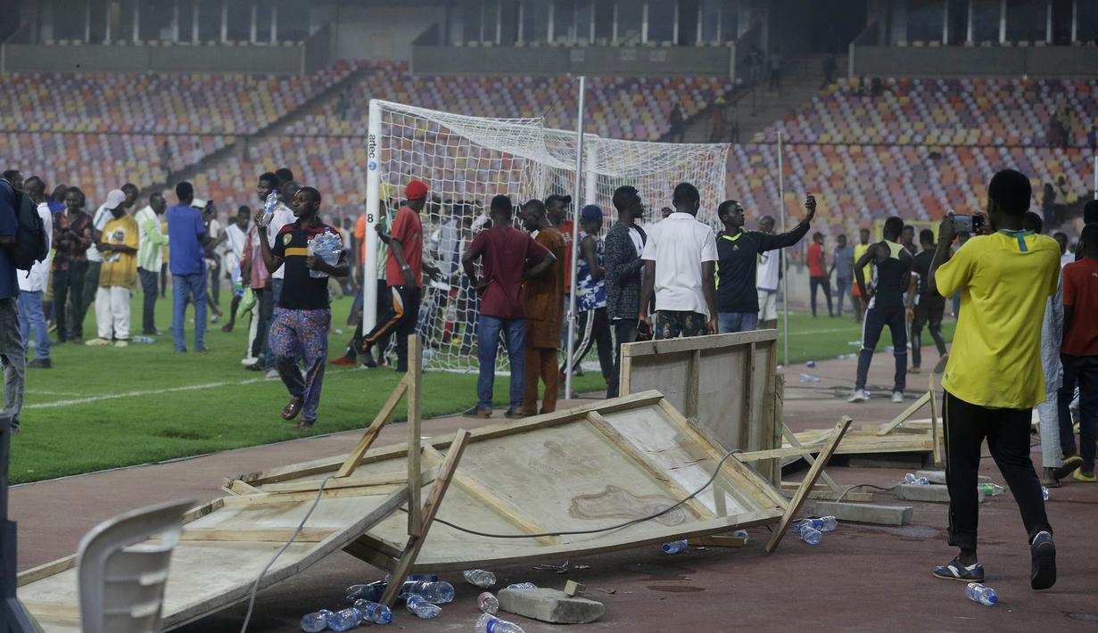 Usai wasit meniup peluit akhir pertandingan, para suporter yang berada di tribun pun menerobos masuk ke dalam lapangan. (AP/Sunday Alamba)