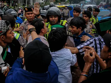 Aktivis HMI beradu mulut dengan polisi saat melakukan demo di Jalan Cikini, Jakarta, Sabtu (8/10). Mereka menuntut Basuki Tjahaja Purnama (Ahok) mempertanggungjawabkan pernyataannya yang dinilai mencederai kitab suci Alquran. (Liputan6.com/Faizal Fanani)